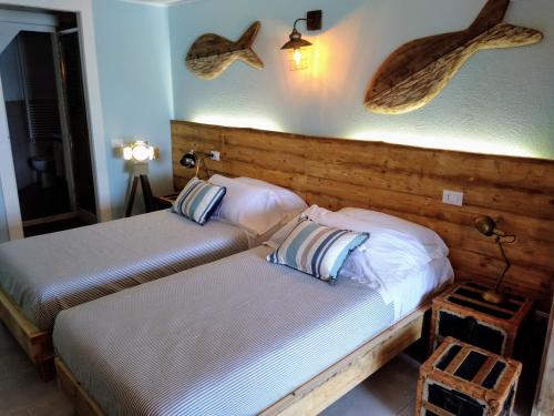 韦内雷港La Calata的两张床铺,位于酒店房间,墙上挂着鱼