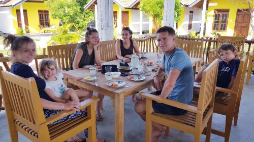 阿鲁甘湾Exotic Beach Hotel的一群人坐在木桌旁