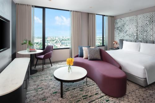曼谷Avani Sukhumvit Bangkok Hotel的酒店客房设有一张大床和一张沙发。