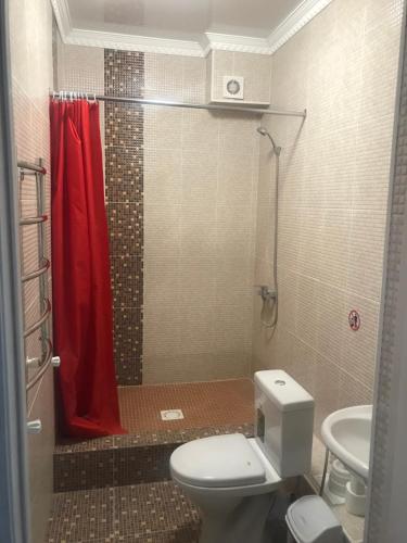 阿克托比Hotel Barhat Аktobe的浴室设有卫生间和带红色淋浴帘的淋浴。