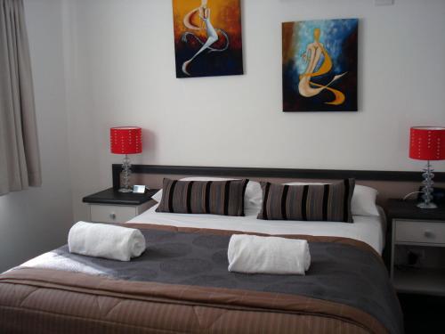 Oakey奥基汽车旅馆的卧室配有一张床,墙上挂有两幅画