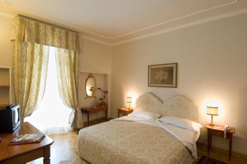 蒙特卡蒂尼泰尔梅卡普利酒店的一间卧室设有一张床和一个大窗户