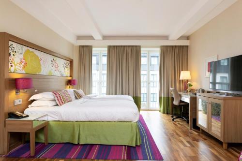马尔默Elite Hotel Esplanade的酒店客房设有一张大床和一张书桌。