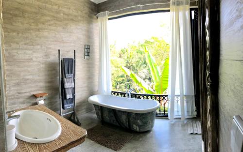 乌布Puri Kasih Gottlieb的一间带大浴缸和窗户的浴室