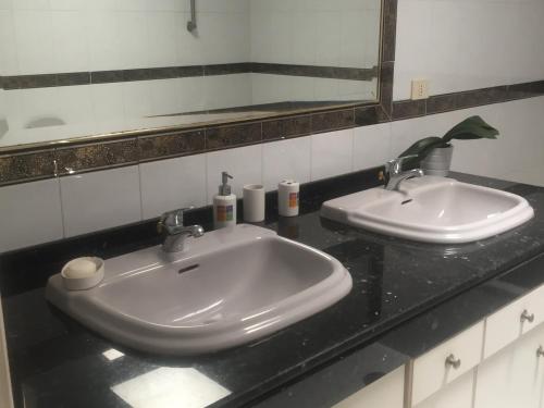 罗萨里奥港Mi casa的浴室柜台设有两个盥洗盆和镜子
