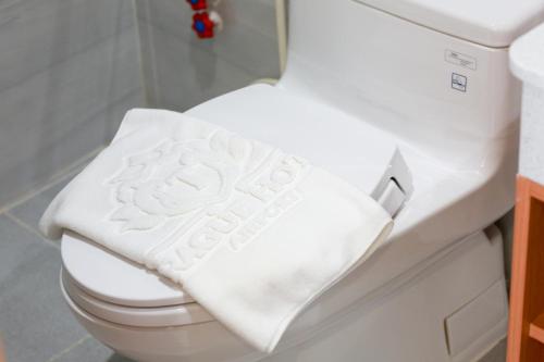 胡志明市Prague Saigon Airport Hotel的浴室内厕所的白色毛巾