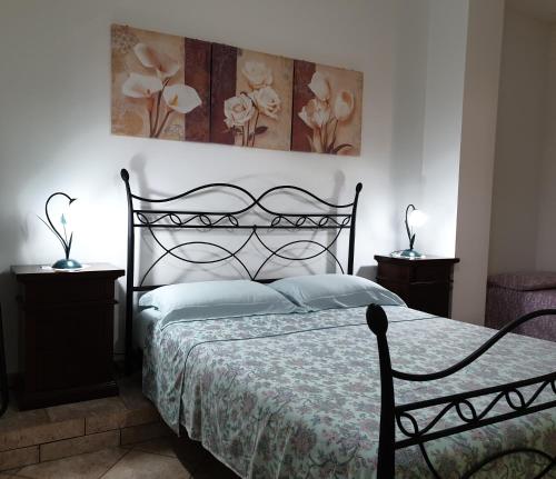 奥里亚case vacanze, La casa di Angelo, con terrazzo的一间卧室配有黑色的床和2个床头柜