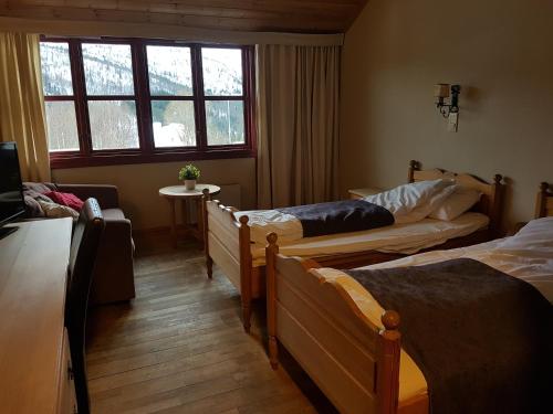 比克勒毕可拉酒店的带三张床和窗户的客房