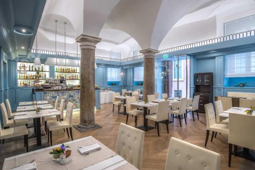 罗马马尔蒂斯宫殿酒店的一间带桌椅的餐厅和一间酒吧
