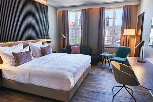 德累斯顿施泰根博阁萨克斯饭店的酒店客房,配有一张床、一张桌子和椅子
