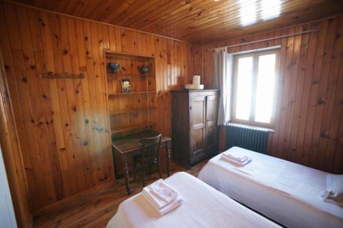 Villar-dʼArèneChez Jean Pierre - Bedroom in a 17th century house - n 4的一间卧室设有两张床、一个窗口和一张书桌