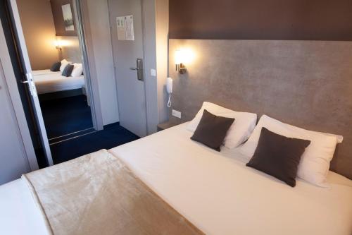 克莱蒙费朗星月酒店的卧室配有一张带两个枕头的大白色床