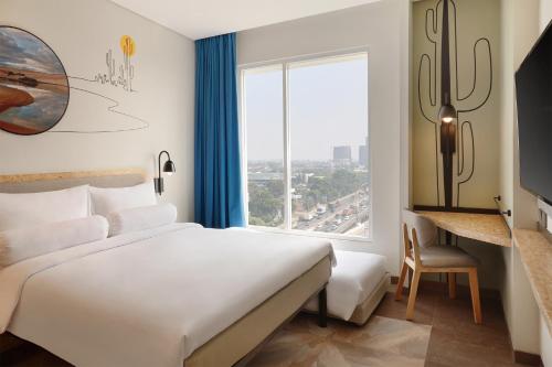 雅加达ibis Styles Jakarta Simatupang的一间卧室设有一张大床和一个大窗户