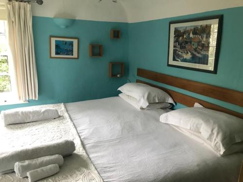 泰克利白宫酒店的卧室设有两张床铺和蓝色的墙壁