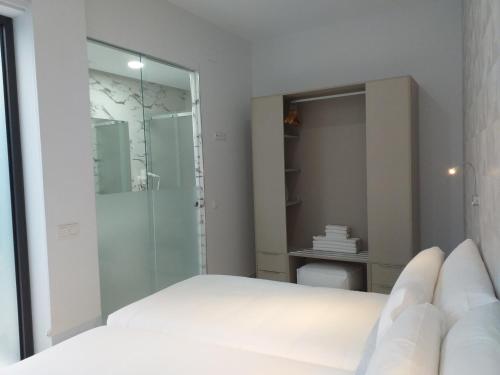 塞维利亚Apartamentos Rivero 8的带淋浴和床的白色卧室