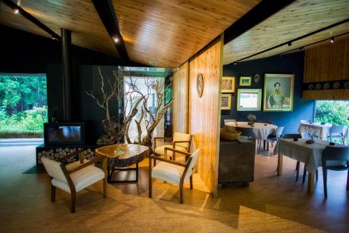 富尔纳斯Furnas Lake Forest Living的客厅配有桌椅和电视。