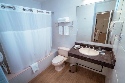 齐克拉约奇克拉约温德姆太阳海岸酒店的一间带卫生间、水槽和镜子的浴室