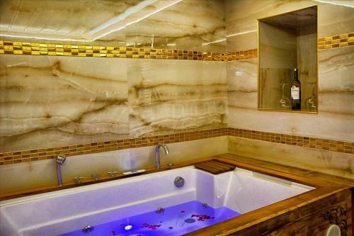 于尔居普Kayhan Cave Villa的设有带大浴缸及镜子的浴室