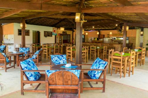 普拉杜古阿比巴宾馆的一间带木桌椅的餐厅和一间酒吧