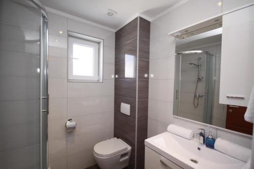 利缇纳Pension Villa Rosa的浴室配有卫生间、盥洗盆和淋浴。