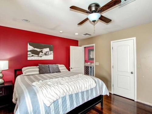 斯科茨Kierland Villa · North Scottsdale Home w/Pool~Walk to Kierland Area的一间带红色墙壁的卧室和一张带吊扇的床