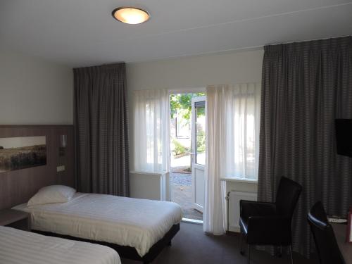 OosteindeHotel Ekamper的酒店客房设有两张床和窗户。