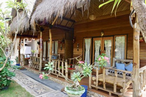 珀尼达岛Pondok Kana And Hostel by Ecommerceloka的一座带门廊和一些植物的木屋
