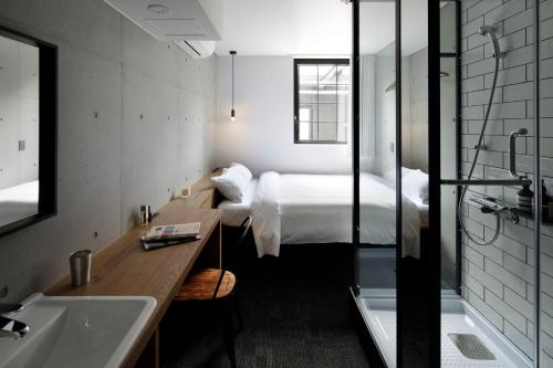 东京HOTEL CEN的一间卧室配有一张床和一个水槽和一个浴缸