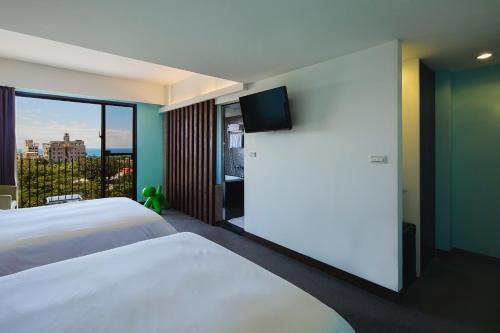 花莲市丽翔酒店连锁花莲馆的酒店客房设有两张床和大窗户。