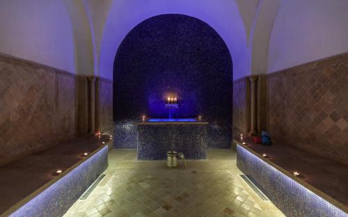 突尼斯Dar El Jeld Hotel and Spa的走廊上设有紫色灯饰的房间,配有桌子