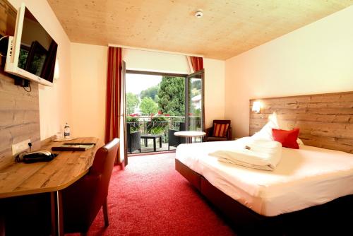 斯堪肯塞尔瓦尔德布里克酒店的配有一张床、一张书桌和一扇窗户的酒店客房