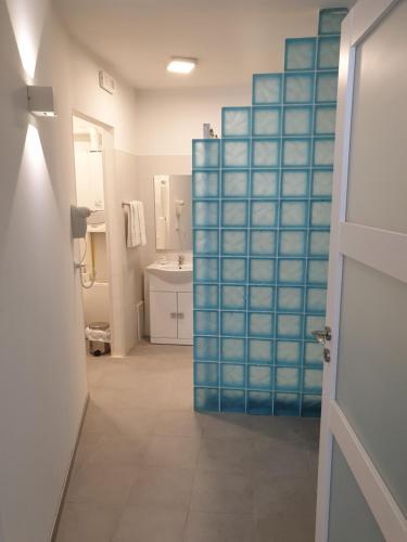 塔尔维西奥Hotel Raibl e Appartamenti的浴室设有蓝色玻璃门和水槽