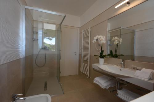 托尔托雷托Residence La Villa的带淋浴、盥洗盆和镜子的浴室