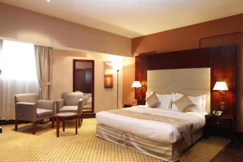 利雅德Haven Plaza的酒店客房,配有一张床和两把椅子
