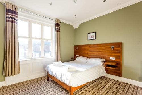 切斯特堡恩洛奇酒店的一间卧室设有一张床和一个大窗户