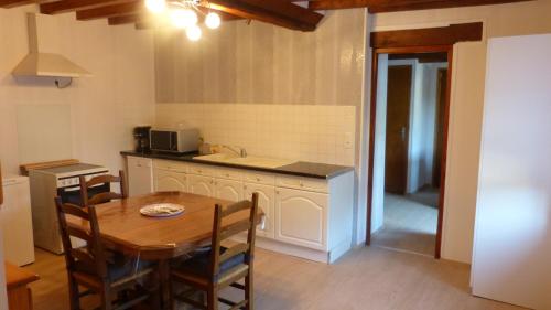 Pertheville-NersLa Maison de Ners的带木桌的厨房和带水槽的厨房