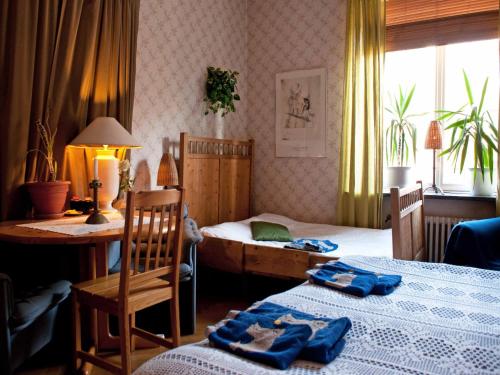 哥德堡艾卡兰达住宿加早餐旅馆的一间卧室配有两张床、一张桌子和一张书桌