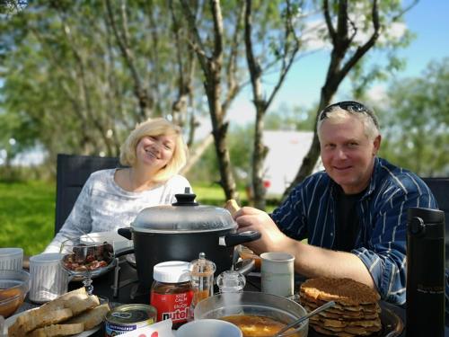 海拉Iceland Igloo Village的坐在餐桌旁吃饭的男人和女人