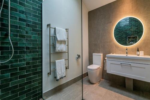 怀蒂昂格Wairua Lodge - Rainforest River Retreat的一间带卫生间、水槽和镜子的浴室