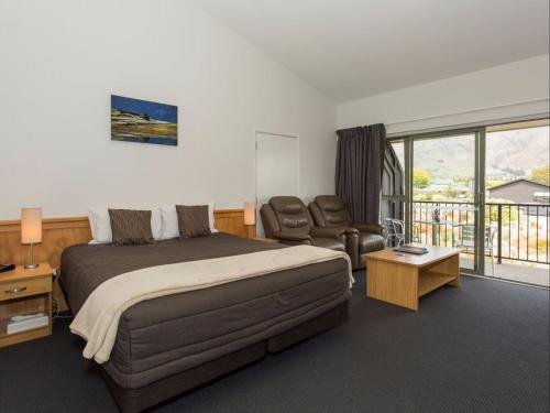瓦纳卡克里尔布鲁克服务式汽车旅馆&公寓的一间卧室配有一张床、一张沙发和一把椅子