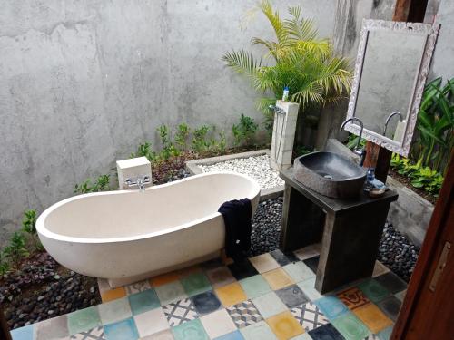 德格拉朗Ubud Sawah Scenery Villa and Homestay的浴缸位于瓷砖地板,配有水槽