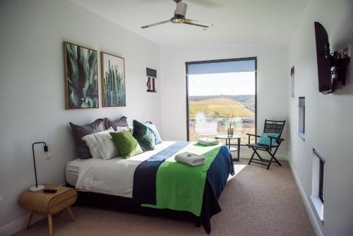 奥兰治蜻蜓小屋民宿的一间卧室设有一张床和一个大窗户
