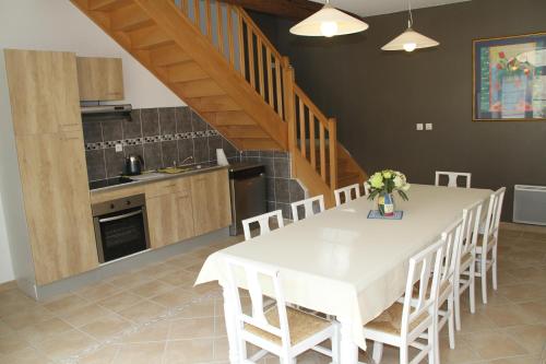 BitryAlba Cottage的厨房以及带白色桌椅的用餐室。