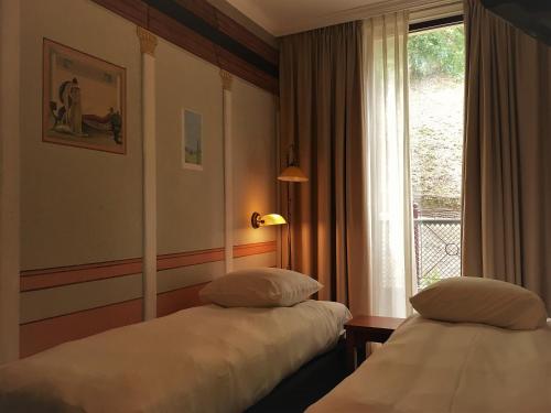 奈梅亨瓦尔卡德勇气酒店的配有窗户的酒店客房内的两张床