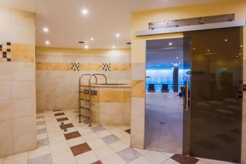 希欧福克CE广场酒店的一间带步入式淋浴间和玻璃门的浴室