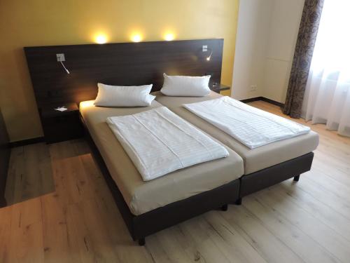 威斯巴登Apart-Hotel Wiesbaden的一间卧室配有一张大床和大床头板