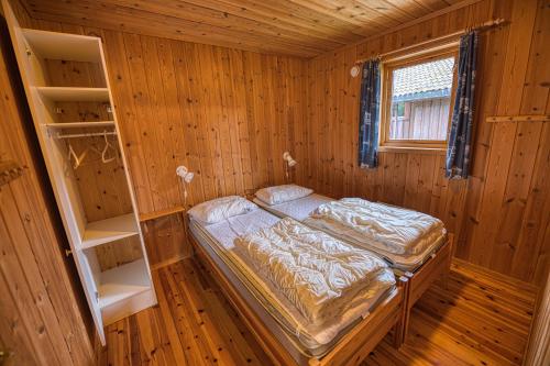 弗罗达尔Vrådal Hyttegrend的木制客房内的一间卧室,配有一张床