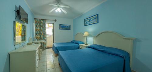 曼萨尼约布拉瓦海岸酒店 的蓝色墙壁客房的两张床
