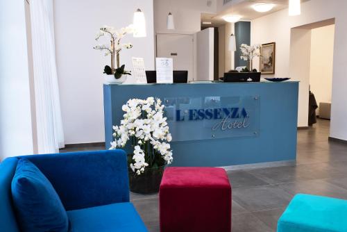 奥尔比亚L'Essenza Hotel的大堂设有鲜花蓝色的墙壁和沙发