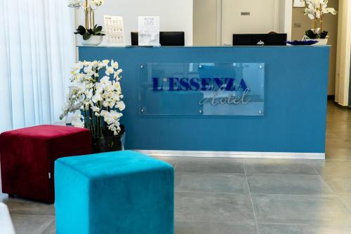 奥尔比亚L'Essenza Hotel的一间拥有鲜花和长凳的蓝色墙壁的房间